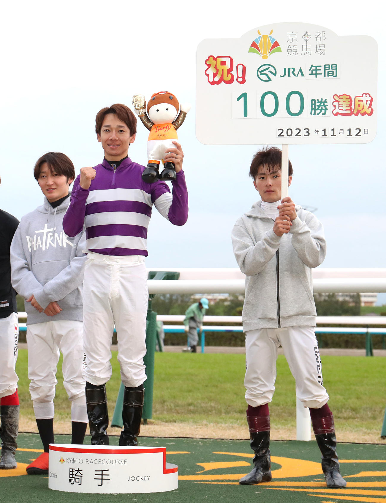 JRA年間100勝を達成しガッツポーズで記念写真に納まる松山騎手（中央）（撮影・白石智彦）