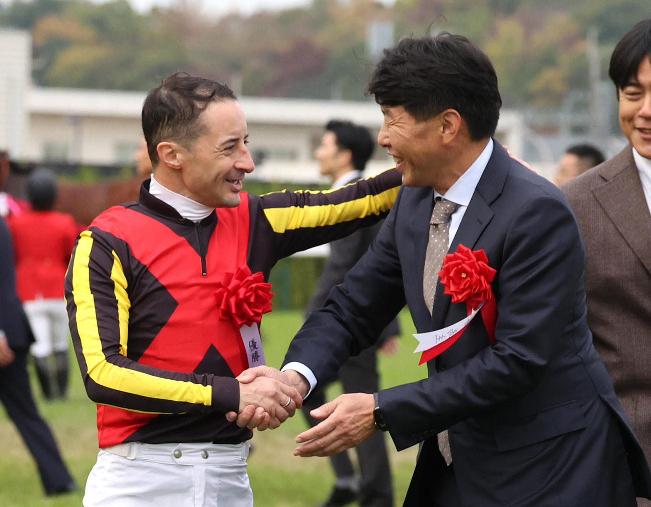 京都11R、笑顔で握手を交わすC・ルメール騎手（左）と吉田俊介氏（撮影・白石智彦）