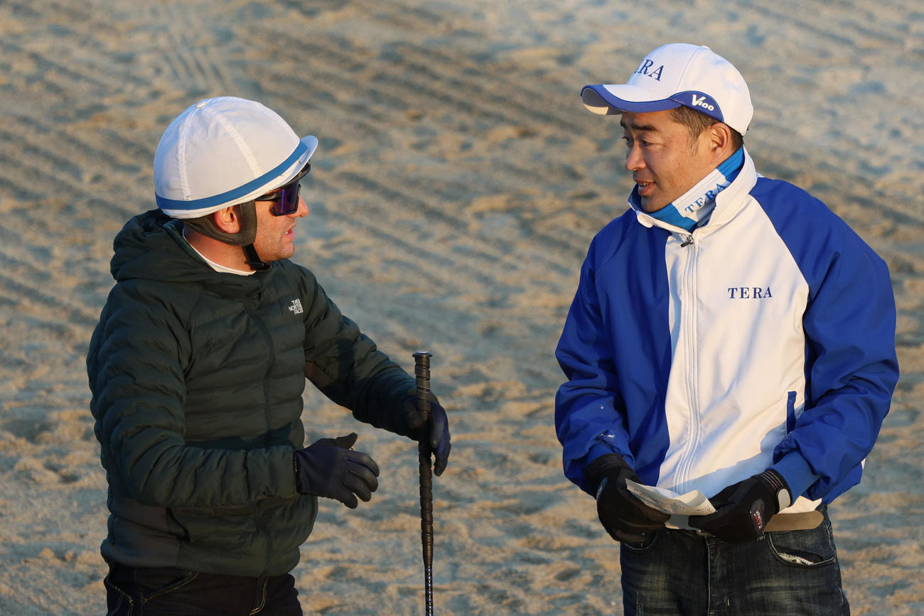 セラフィックコールの追い切りを終え、寺島調教師（右）に感触を伝えるM・デムーロ騎手
