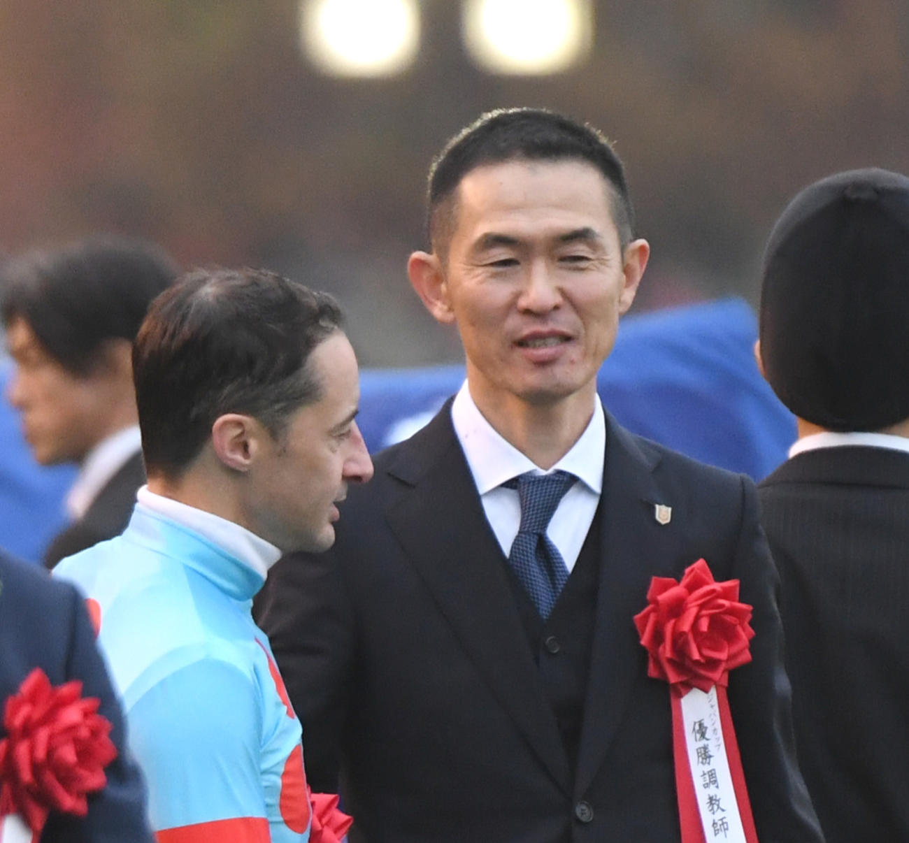26日、ジャパンCを制したイクイノックスのルメール騎手（左）と握手する木村師