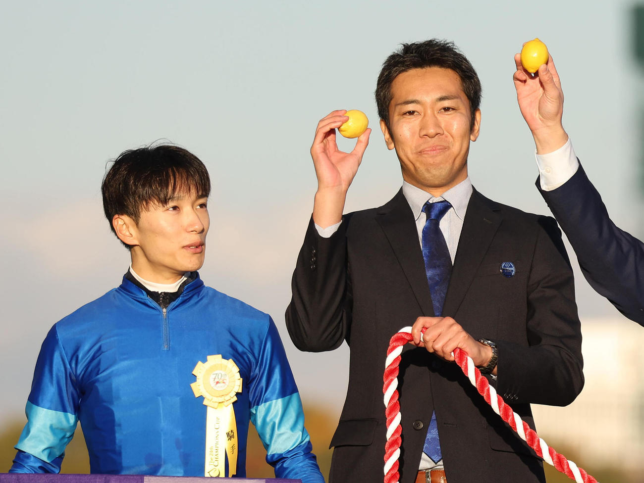 レモンポップの口取りで関係者の掲げるレモンを見る坂井騎手（左）（撮影・白石智彦）