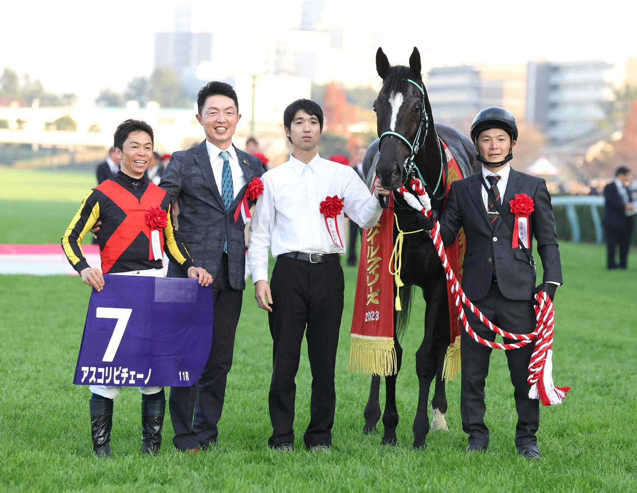 3連勝で阪神JFを制したアスコリピチェーノと口取りに並ぶ左から北村宏騎手、黒岩師（撮影・白石智彦）