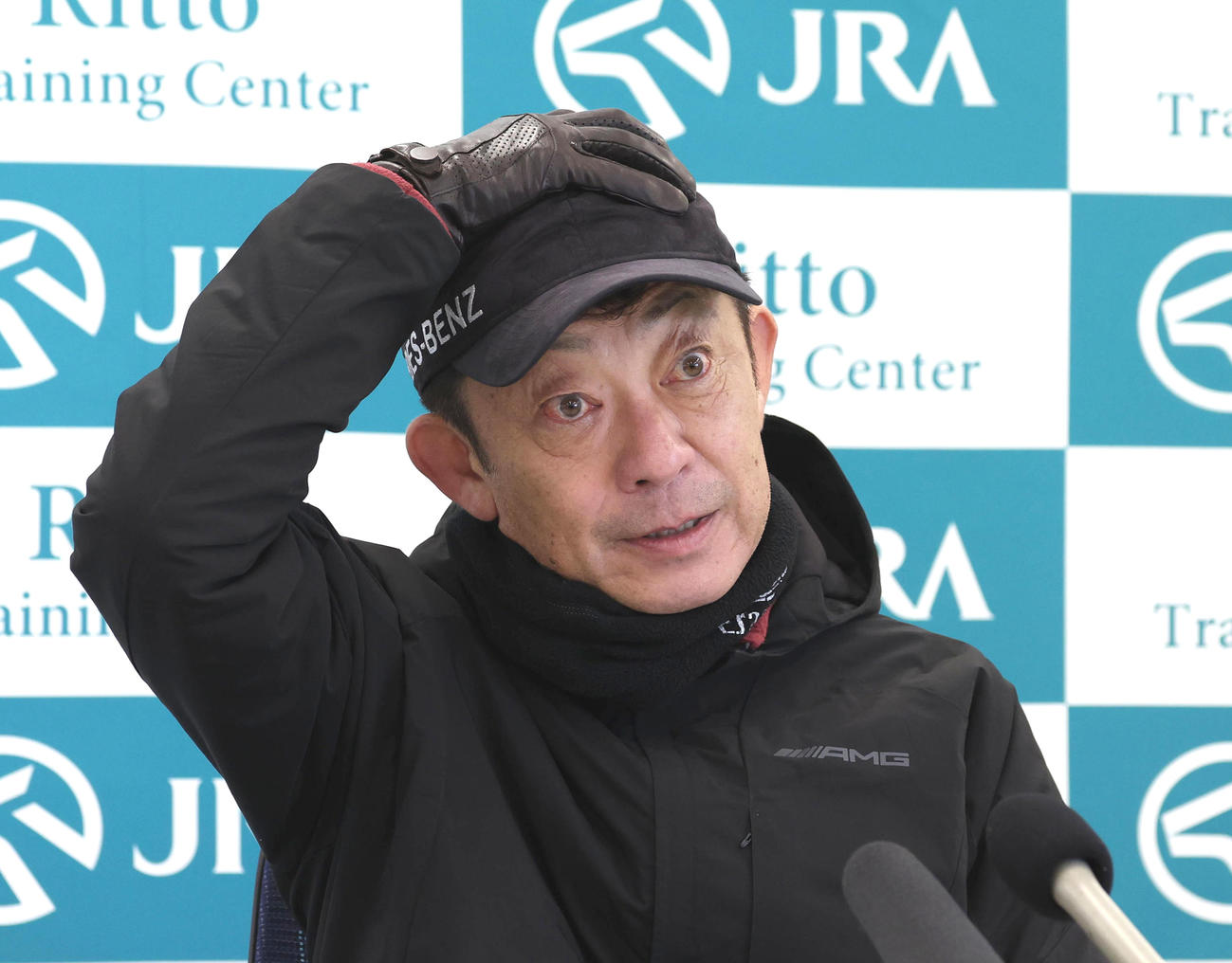 有馬記念の共同会見で頭を押さえる友道師（撮影・白石智彦）