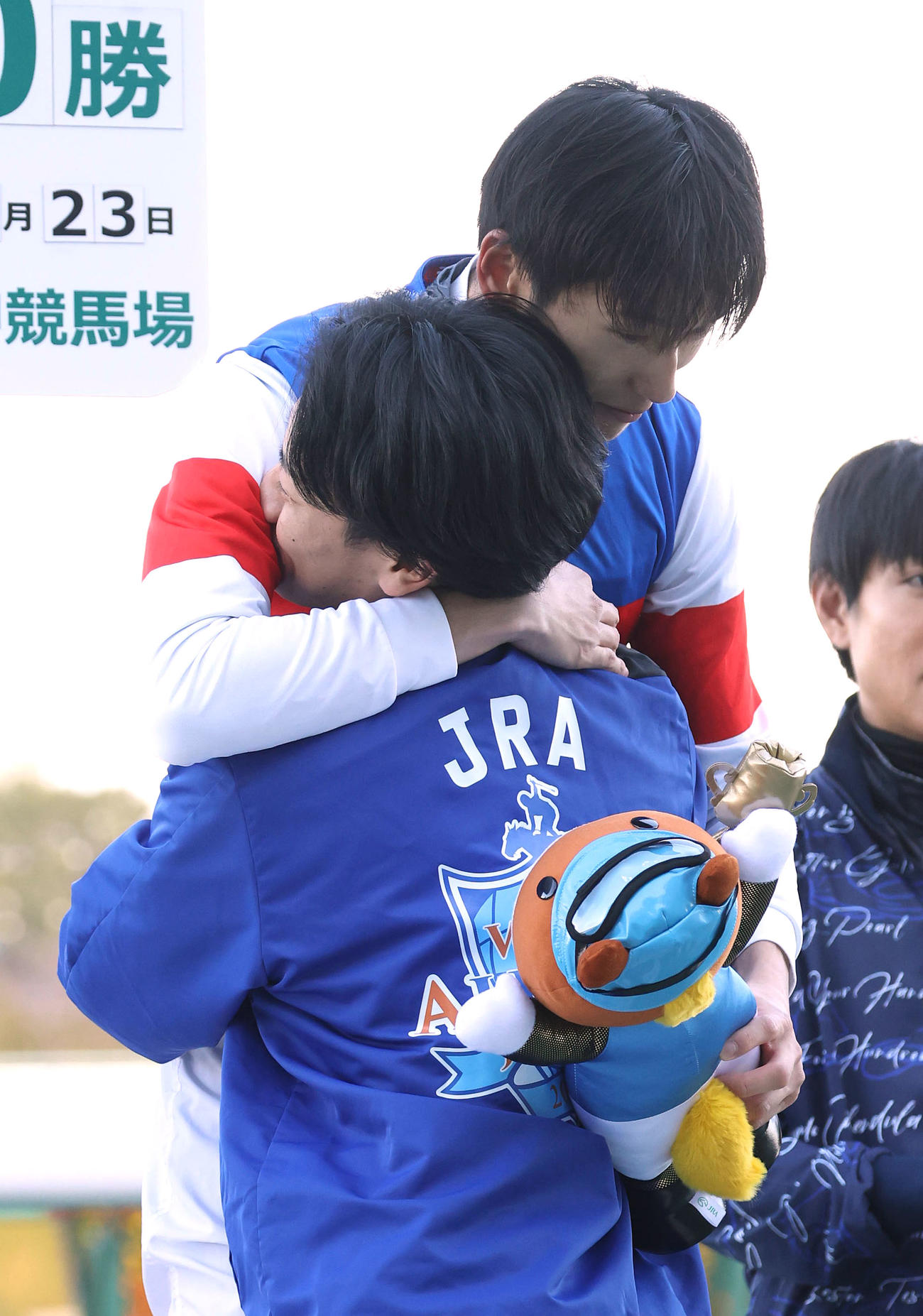 荻野極騎手（手前）を抱きしめるJRA通算400勝を達成した坂井騎手（撮影・白石智彦）