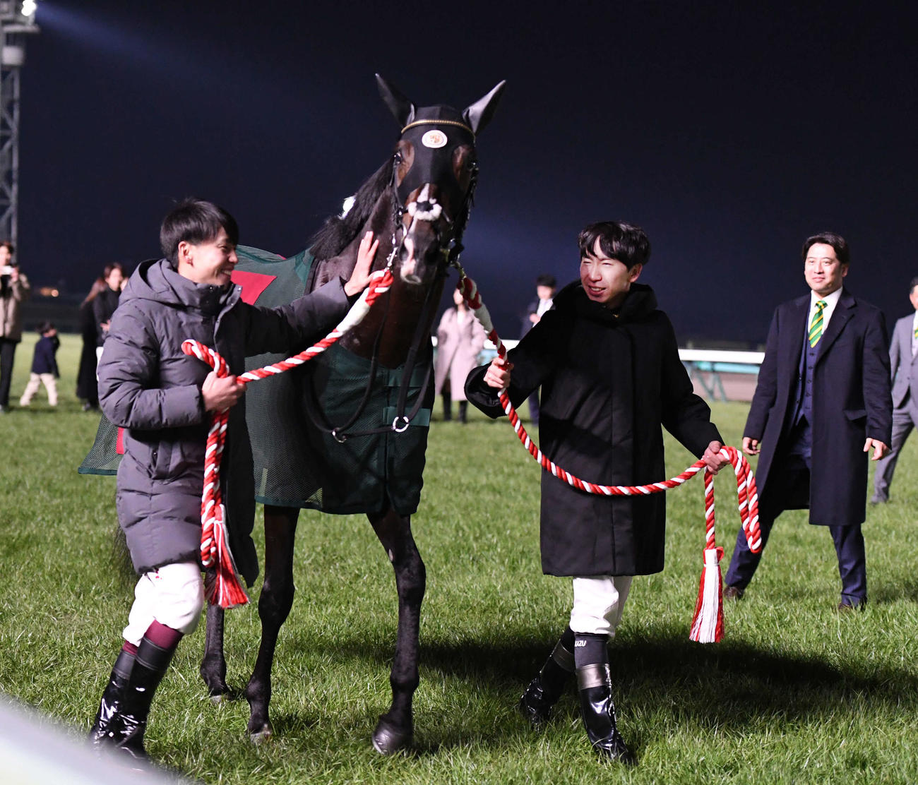 引退式で横山武騎手（左）と横山和騎手がタイトルホルダーの手綱を引く。右は栗田師（撮影・柴田隆二）
