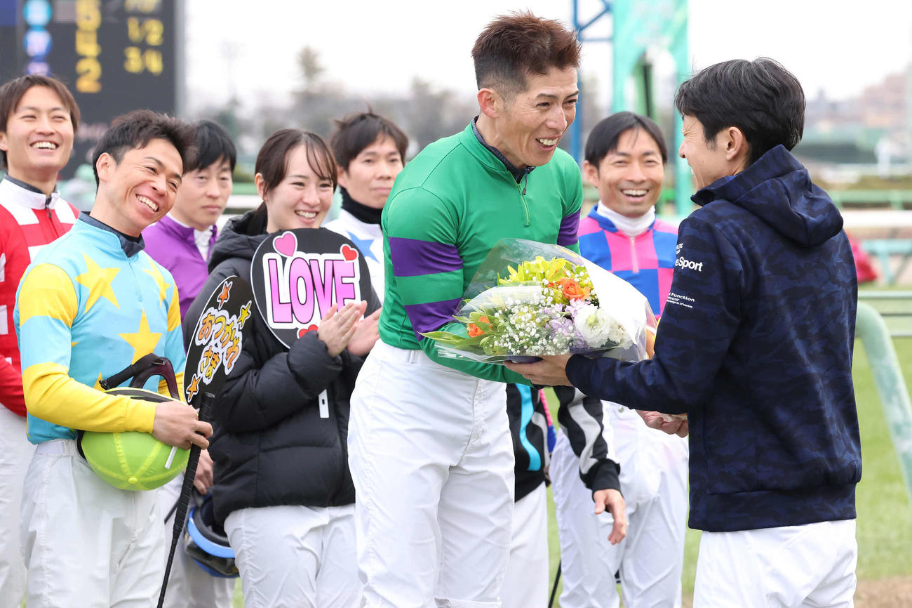 武豊騎手（右）から花束を受け取る柴山騎手（撮影・丹羽敏通）