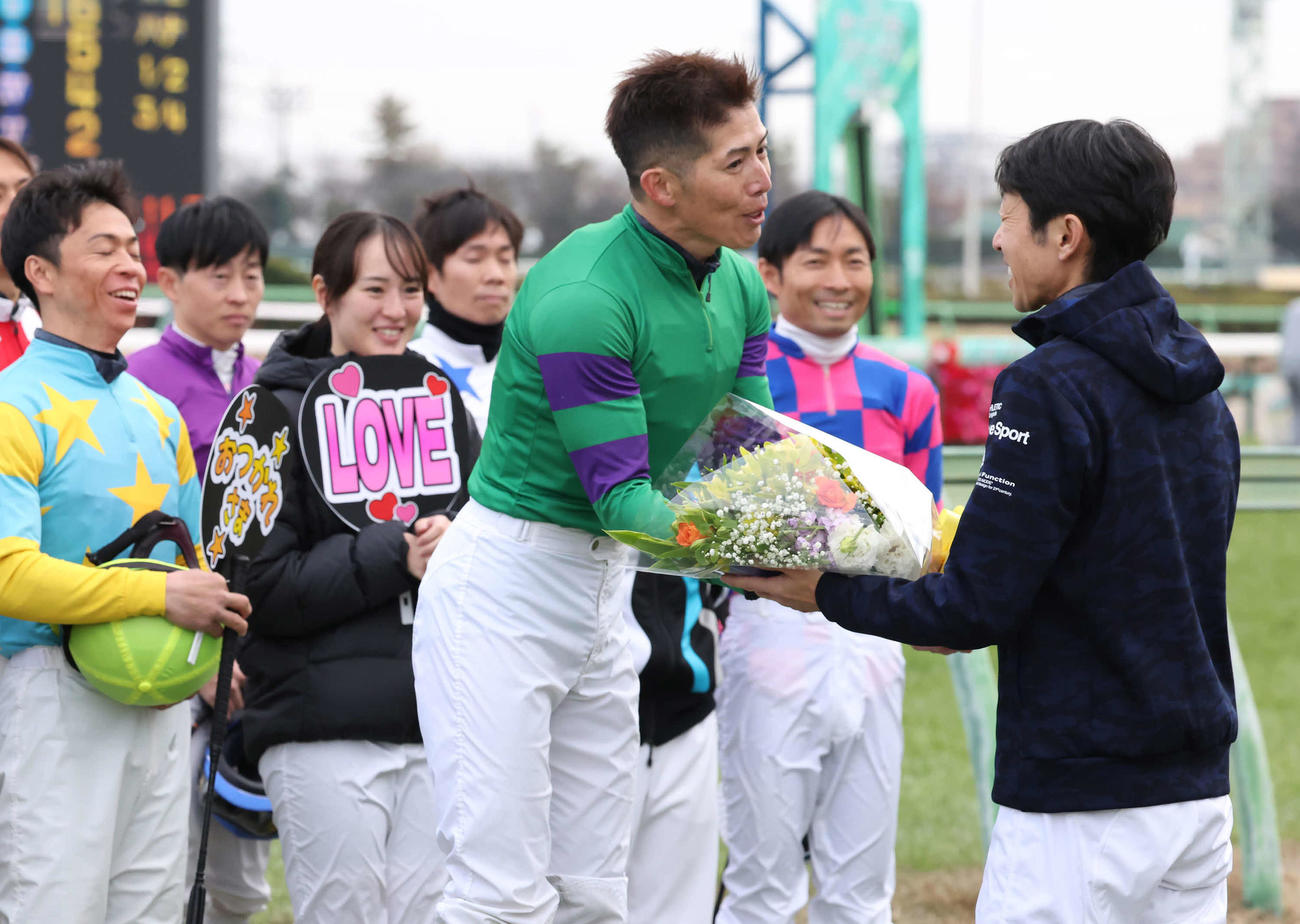 武豊騎手（右）から花束を受け取る柴山騎手（撮影・丹羽敏通）