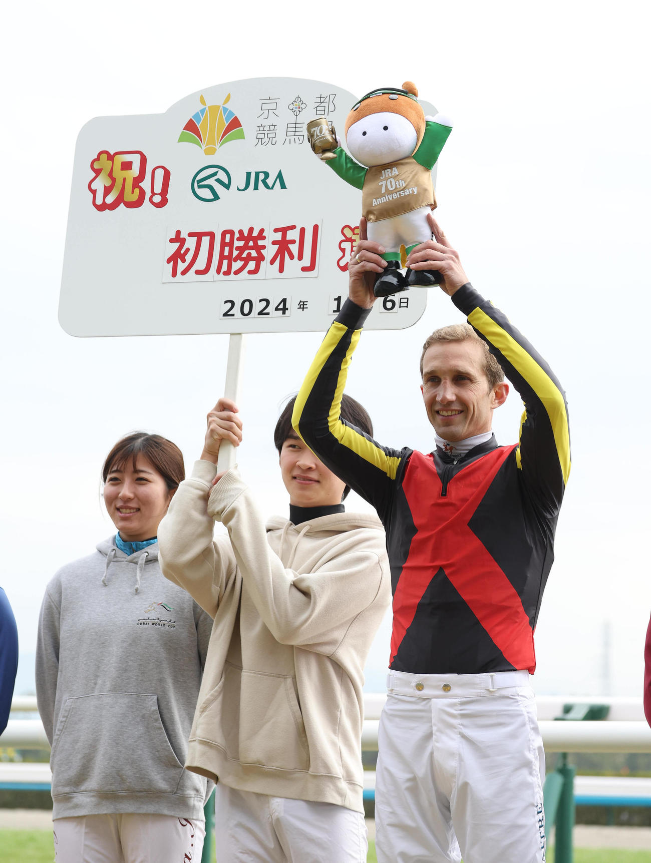 笑顔でターフィー人形を掲げるJRA初勝利のA・ルメートル騎手（右）（撮影・白石智彦）