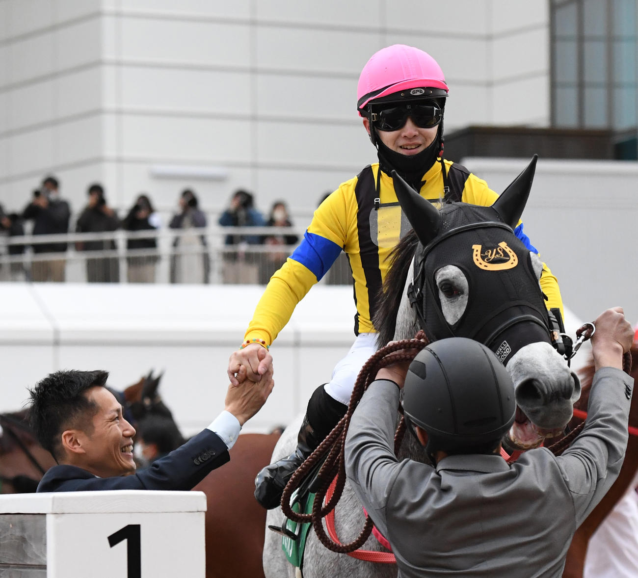 フェアリーSを制したイフェイオンの西村淳騎手（右）は杉山佳調教師と握手する（撮影・柴田隆二）