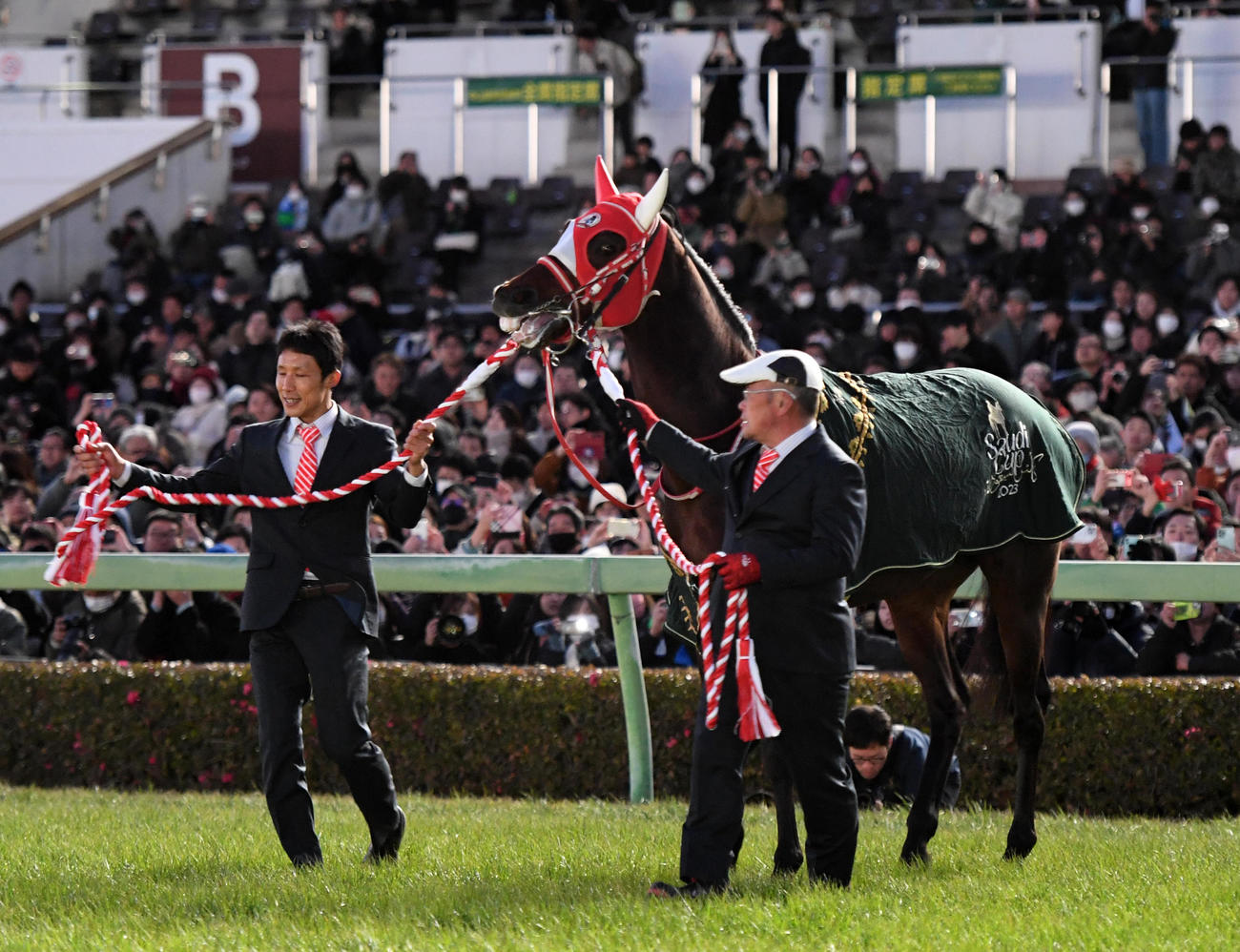 岡調教助手（左）と池田元厩務員に引かれて引退式に臨むパンサラッサ（撮影・柴田隆二）