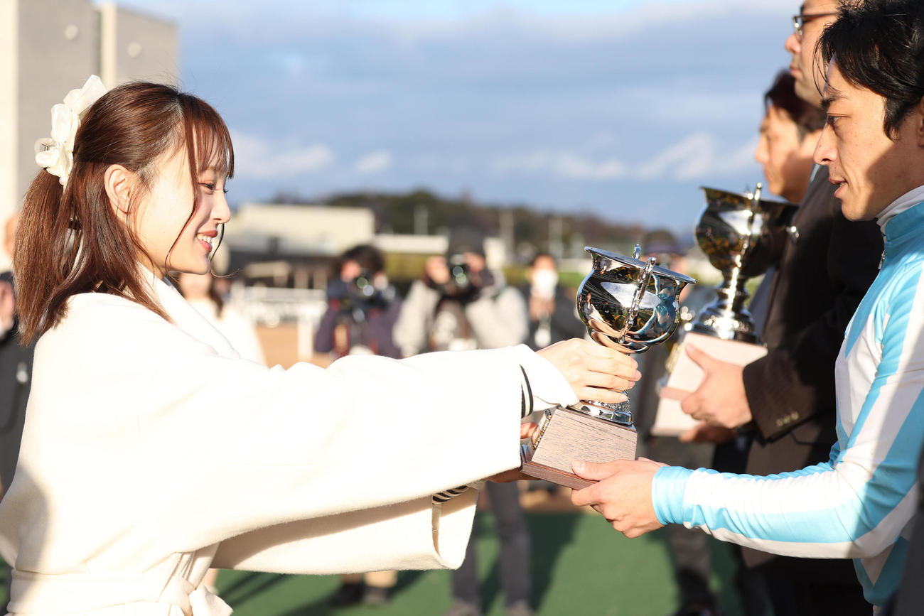 シンザン記念を制した川田騎手（右）にトロフィーを授与するNMB48新澤菜央（撮影・白石智彦）