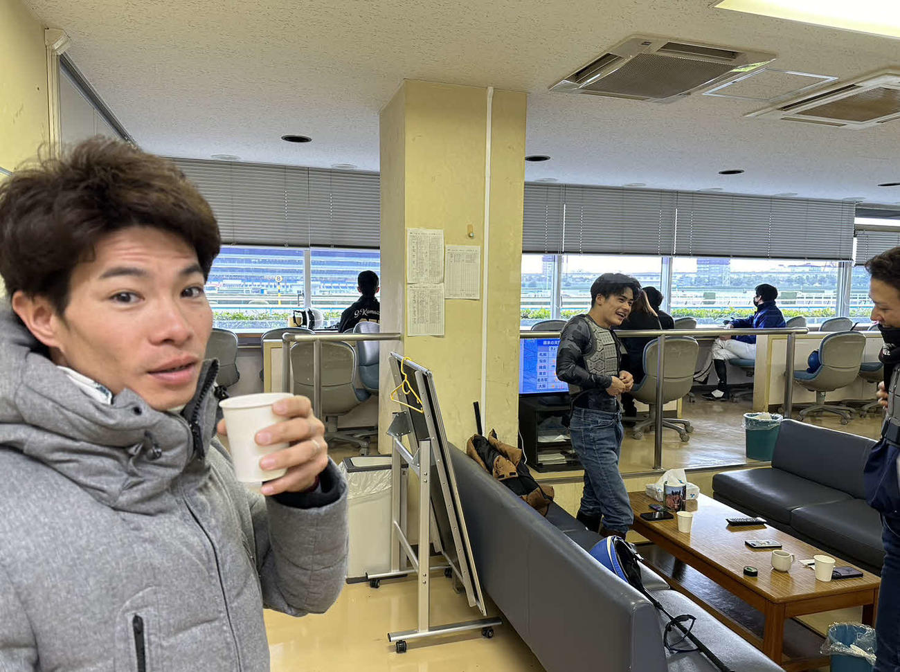 朝の小倉競馬場、スタンドで調教に備えるジョッキーたち（撮影・小野寺祐太）