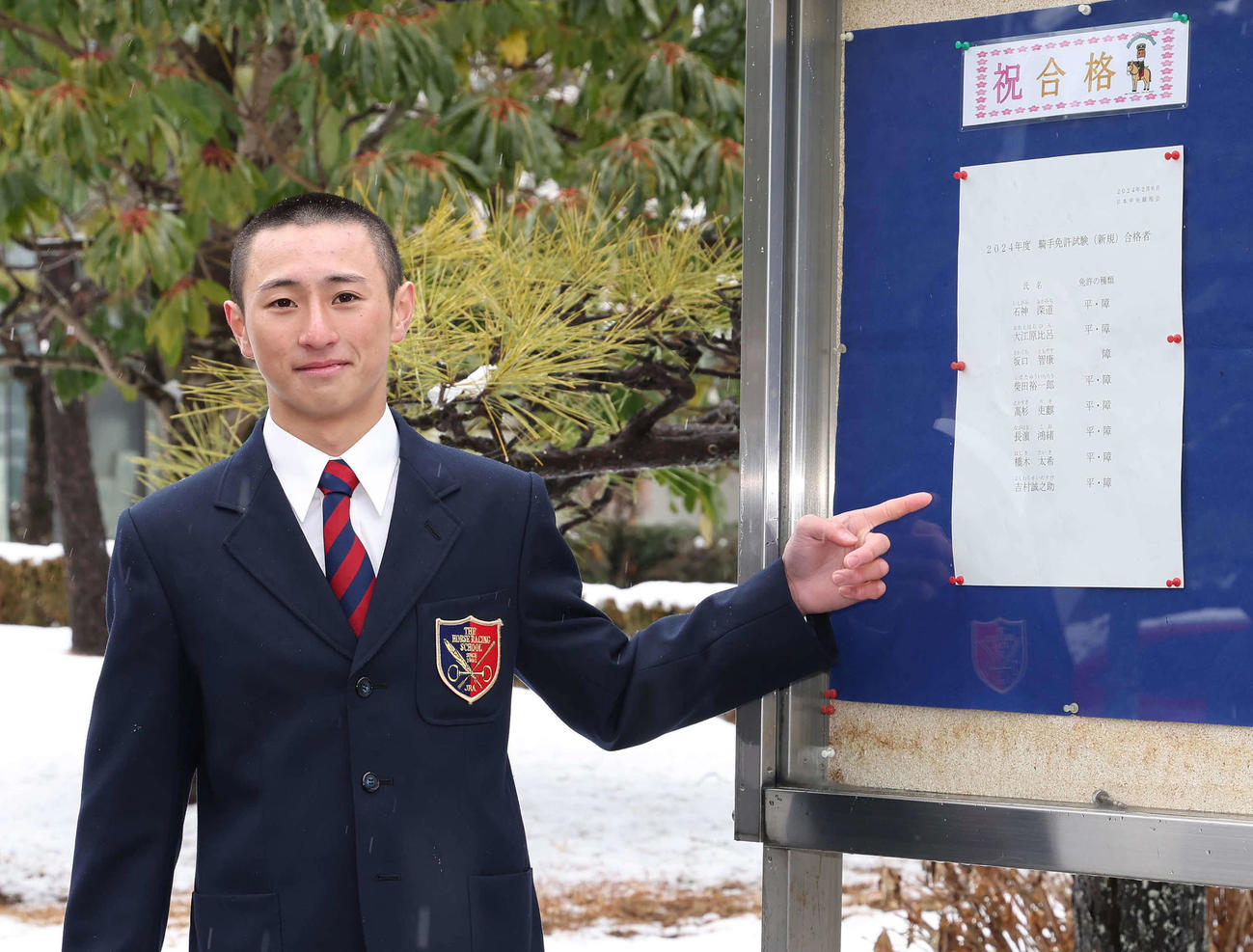 合格者名簿を前に写真に納まる吉村誠之助（撮影・丹羽敏通）