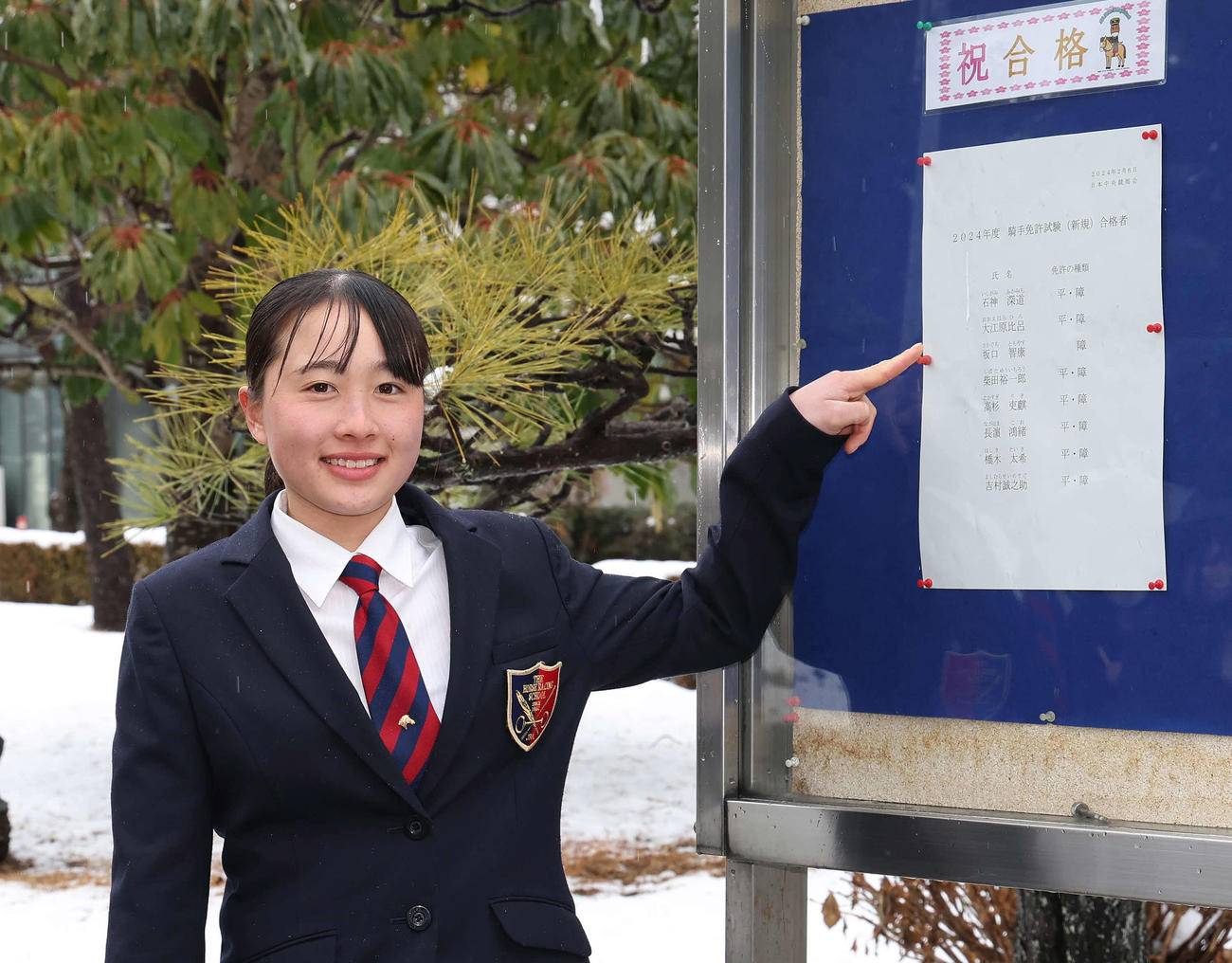 合格者名簿を前に写真に納まる大江原比呂（撮影・丹羽敏通）