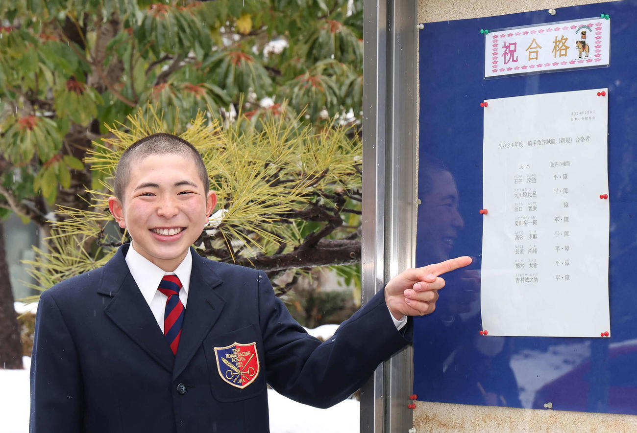 合格者名簿の前で写真に納まる橋木太希（撮影・丹羽敏通）