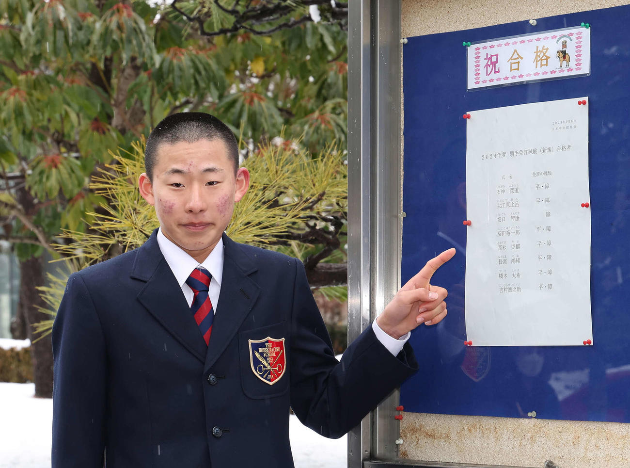 合格者名簿の前で写真に納まる高杉吏麒（撮影・丹羽敏通）