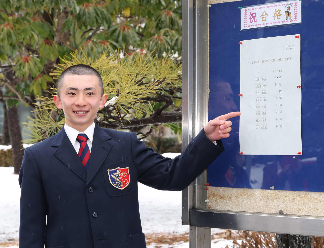 合格者名簿の前で写真に納まる長浜鴻緒（撮影・丹羽敏通）