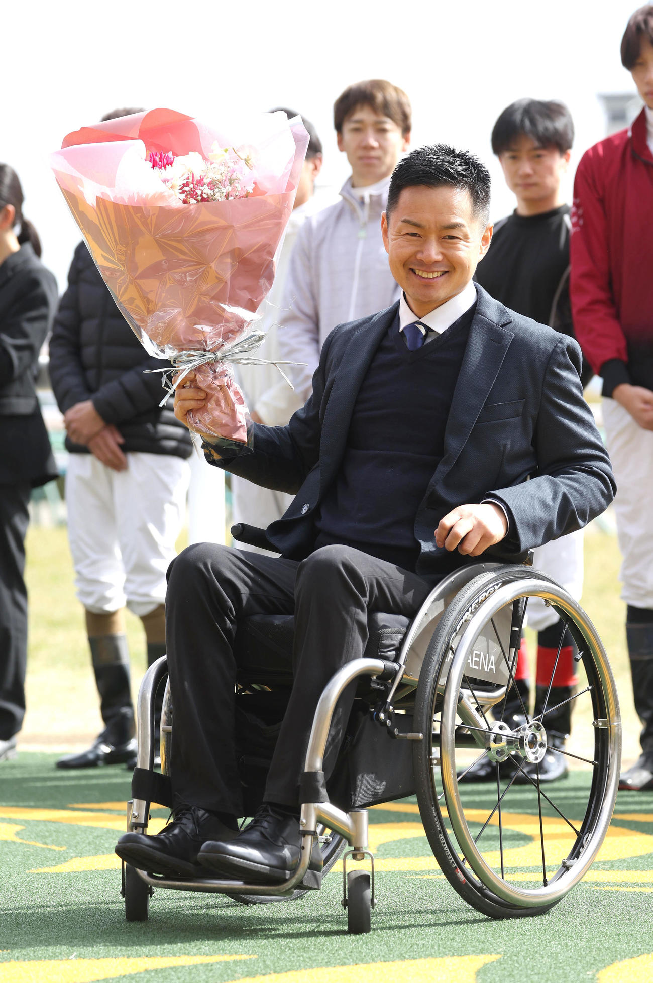 引退セレモニーで笑顔で花束を掲げる藤井騎手（撮影・白石智彦）