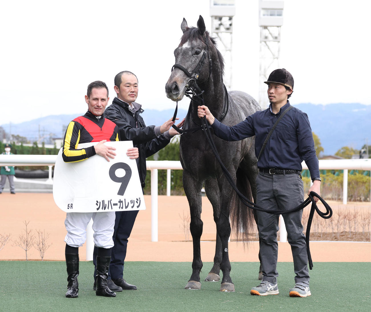 3歳未勝利を勝ち上がったシルバーカレッジと口取りに並ぶM・デムーロ騎手（左）（撮影・白石智彦）