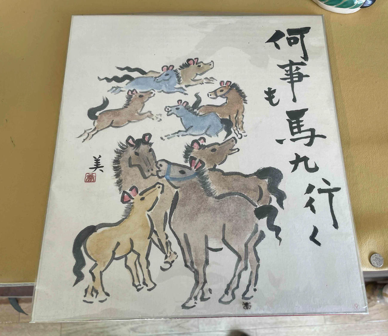 高橋裕師の厩舎に飾られた馬たちが戯れる絵。「何事も馬九行く」とメッセージが書かれている