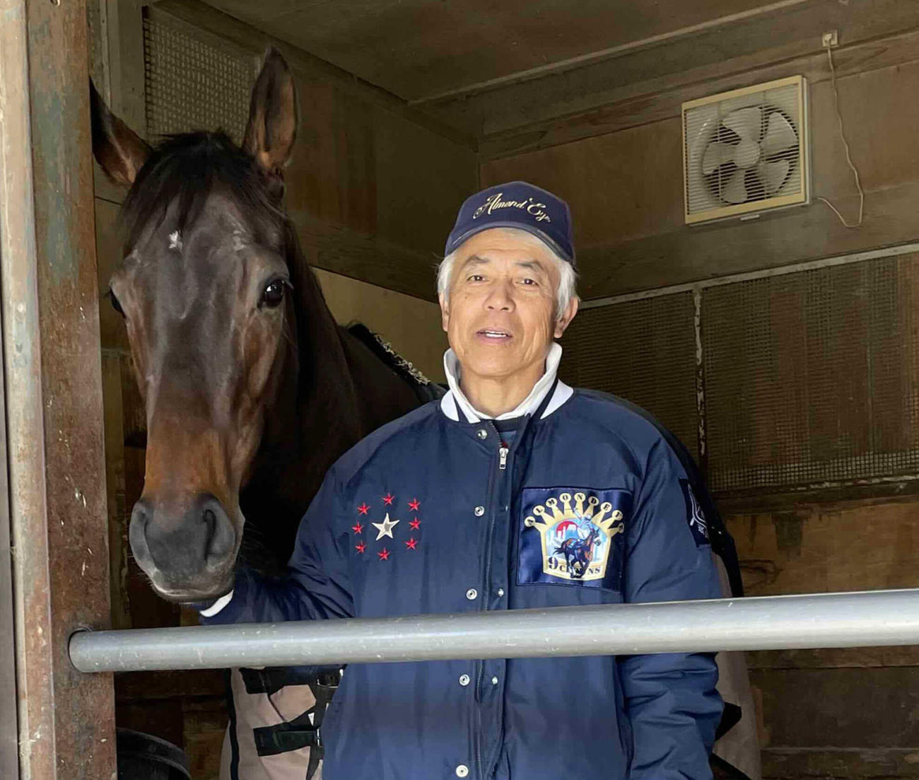 馬房でくつろぐミラビリスマジックと国枝師