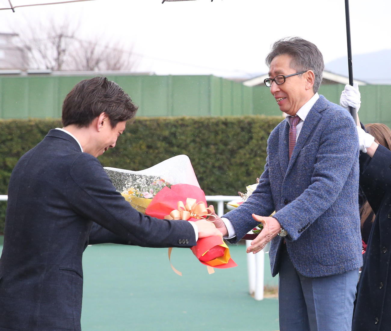 引退セレモニーで安田翔伍調教師（左）から花束を贈られる安田隆行調教師（撮影・冨田成美）