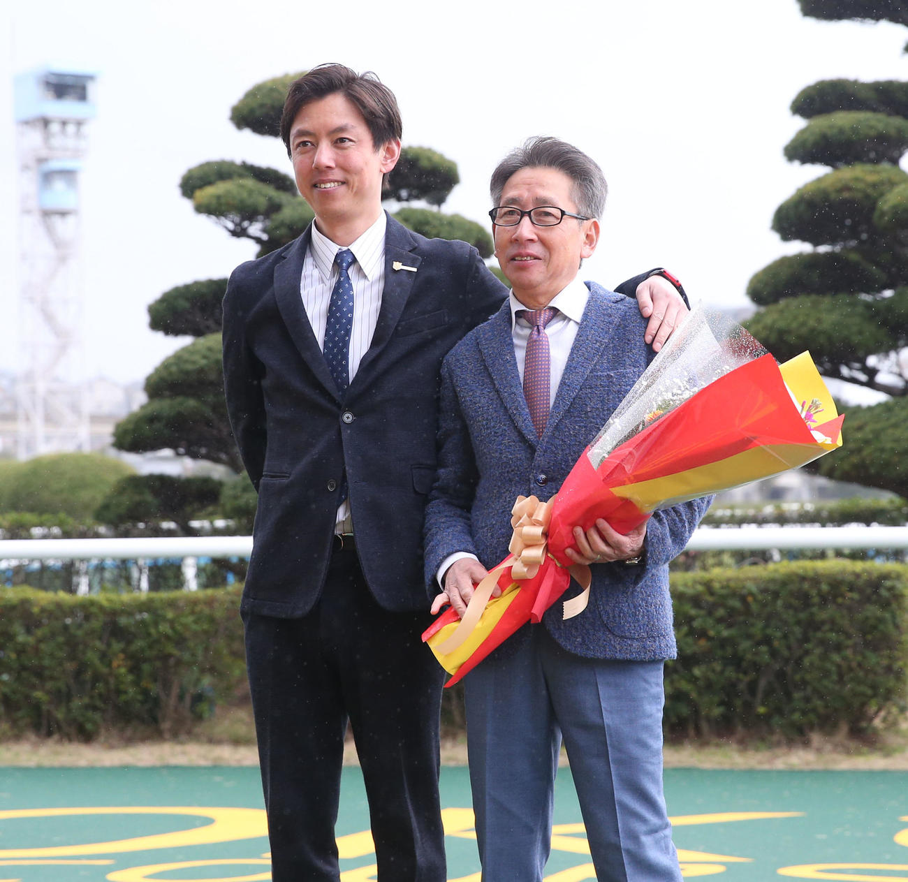 引退セレモニーで記念撮影に納まる、安田翔伍調教師（左）と安田隆行調教師（撮影・冨田成美）