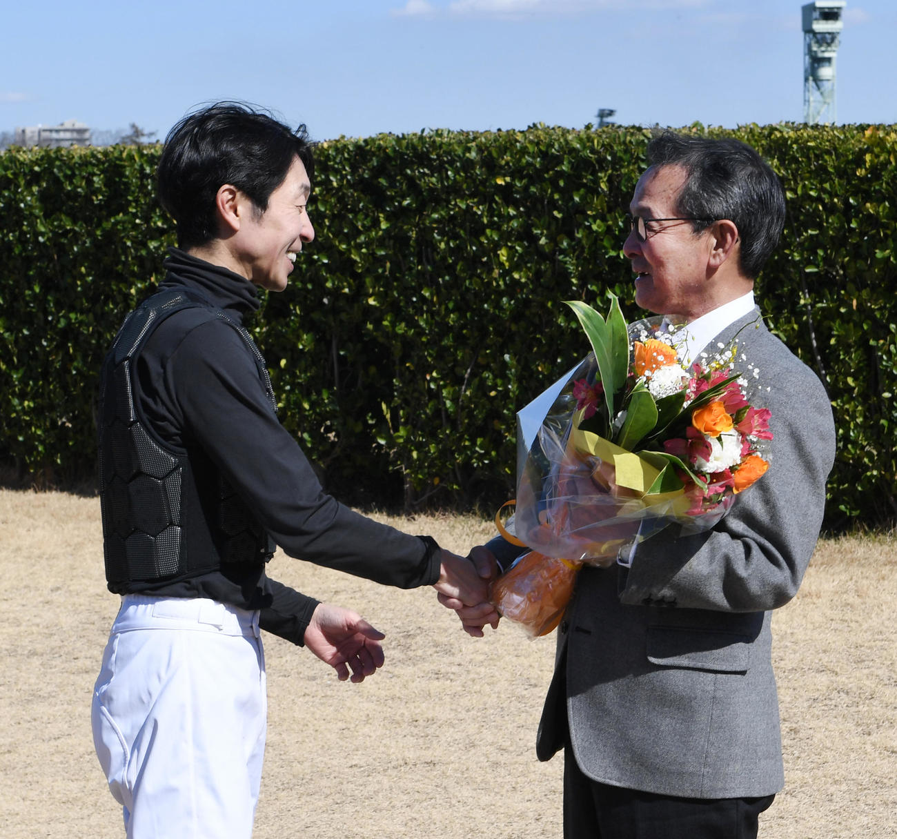 引退セレモニーで武豊騎手から花束を贈られる中野栄治調教師（右）（撮影・柴田隆二）