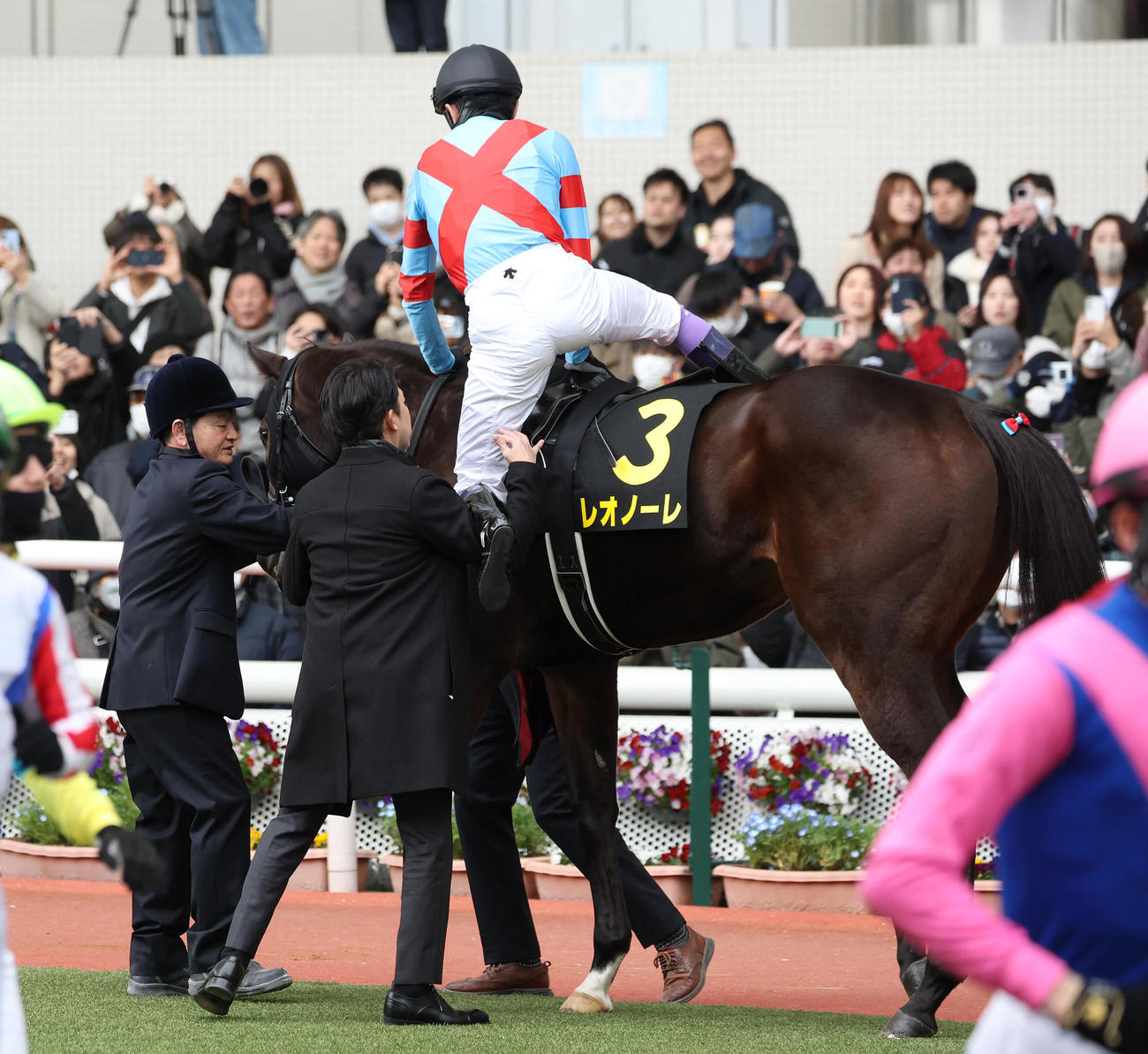 阪神11R、レオノーレに騎乗する武豊騎手の足を上げる福永師（中央）（撮影・白石智彦）