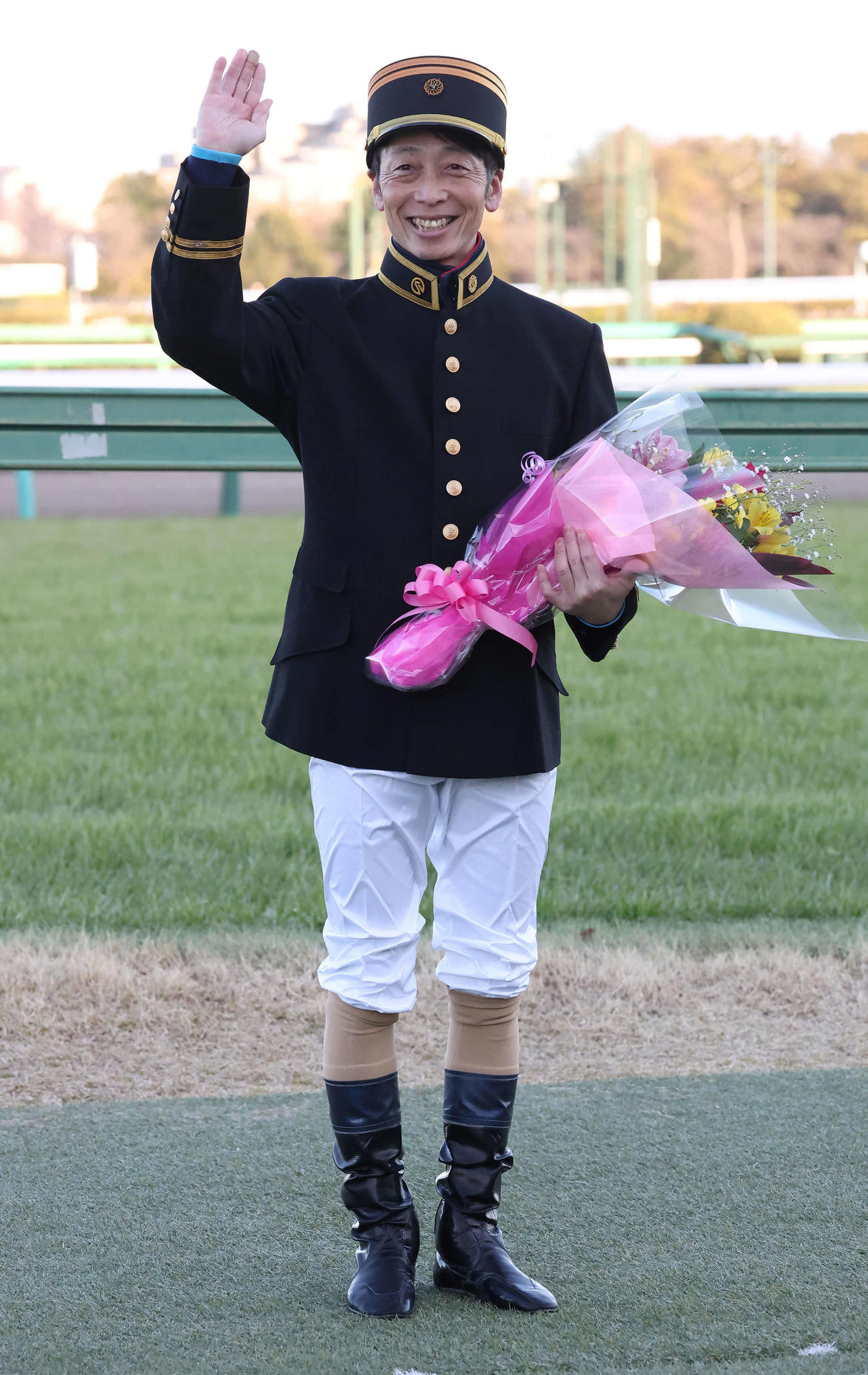 競馬学校の教官の制服を着てファンに手を振る武士沢騎手（撮影・丹羽敏通）