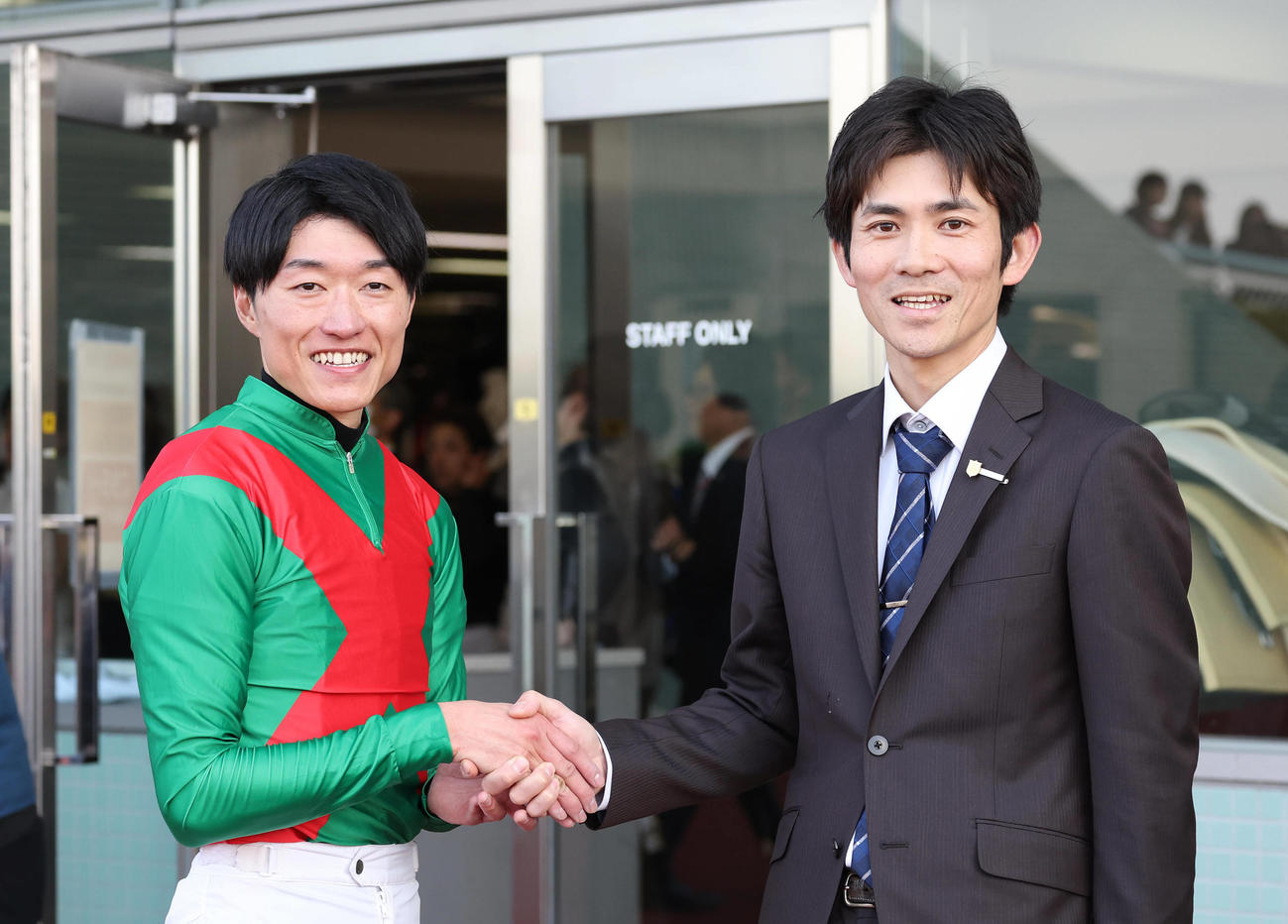阪神12R、ハクサンバードで厩舎初勝利を挙げ笑顔で握手する鮫島良騎手（左）と高橋一師（撮影・白石智彦）