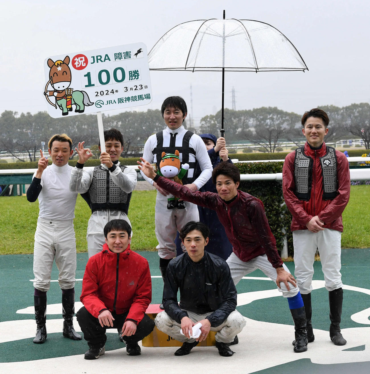 阪神4R、小坂騎手（中央）はメルテミアで障害レース100勝を達成し、祝福を受ける（撮影・前岡正明）