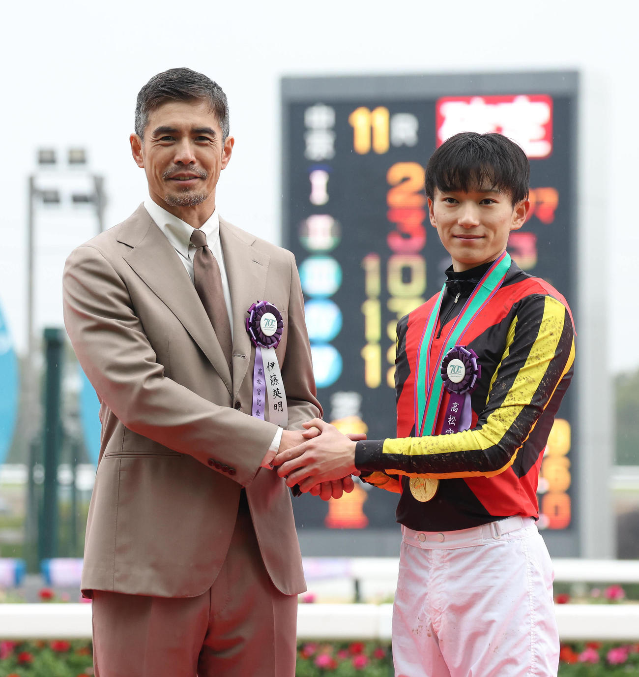 握手するプレゼンターの伊藤英明（左）と坂井騎手（撮影・白石智彦）
