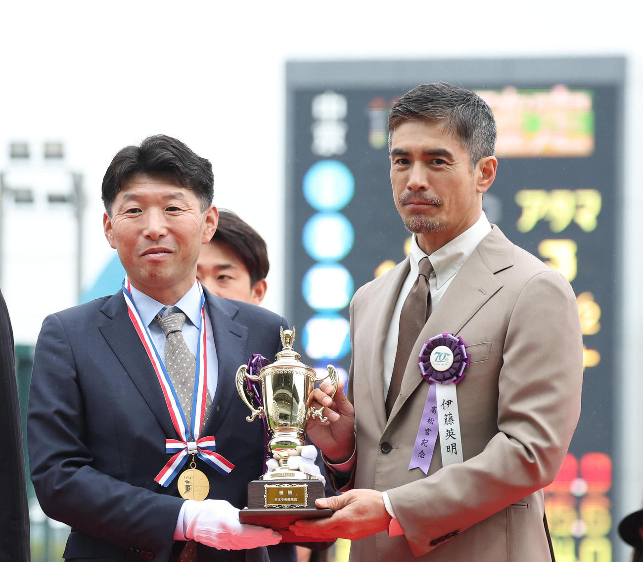 表彰式で記念写真に納まる吉田俊介サンデーR代表（左）とプレゼンターの伊藤英明（撮影・白石智彦）