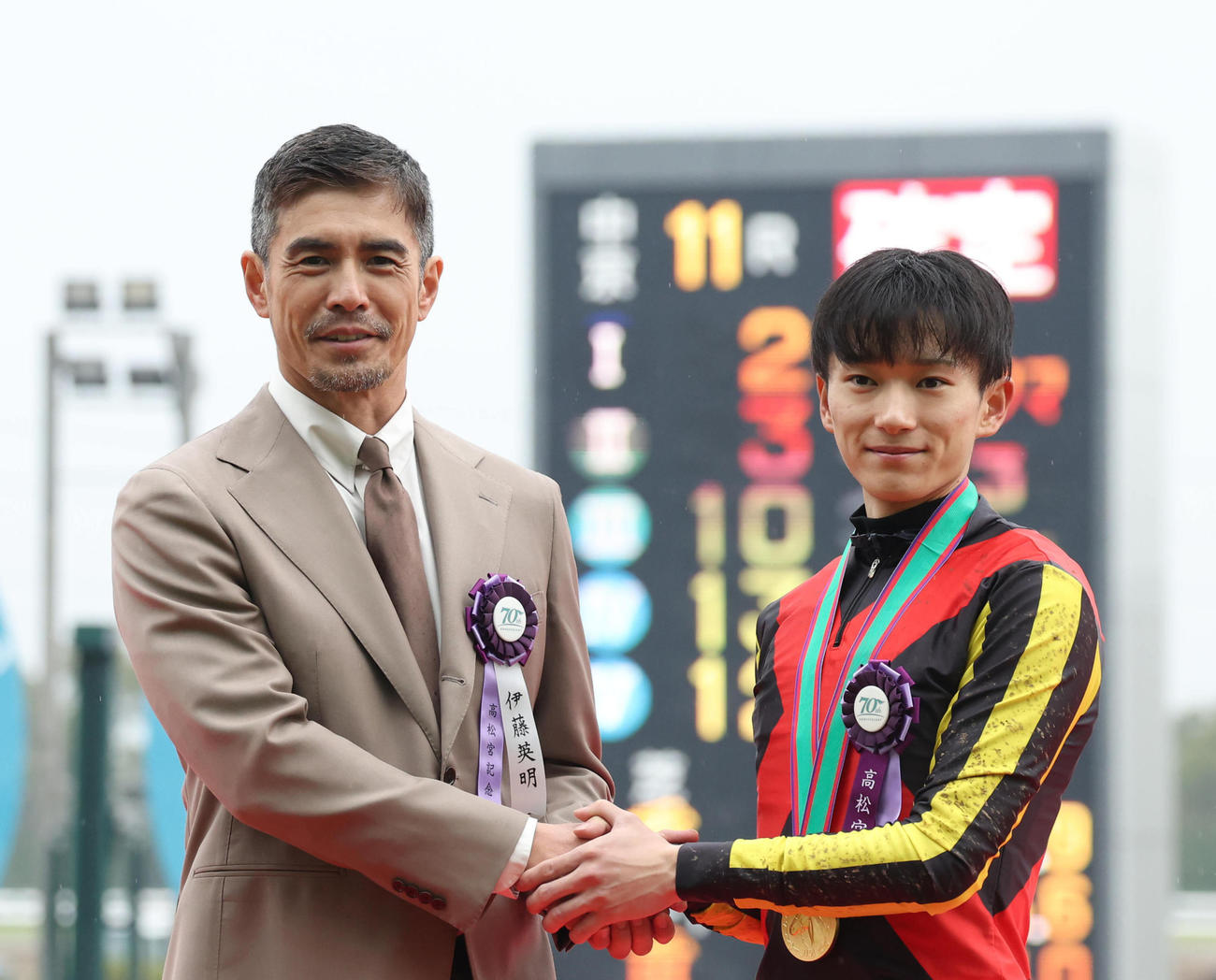 握手するプレゼンターの伊藤英明（左）と坂井騎手（撮影・白石智彦）