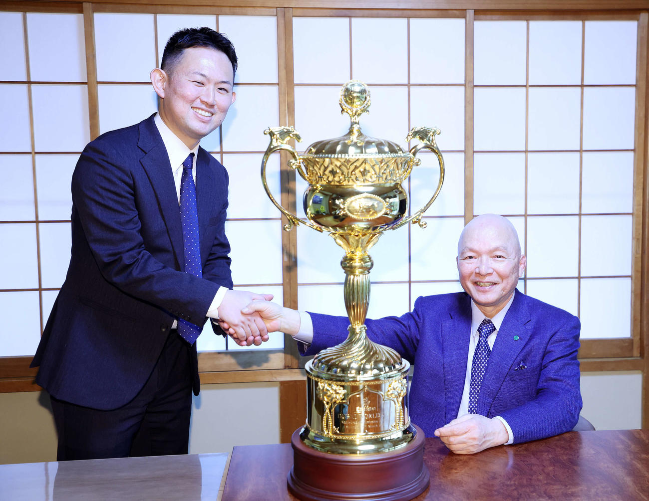 写真に納まる桑原記者（左）と了徳寺健二オーナー（撮影・鈴木正人）