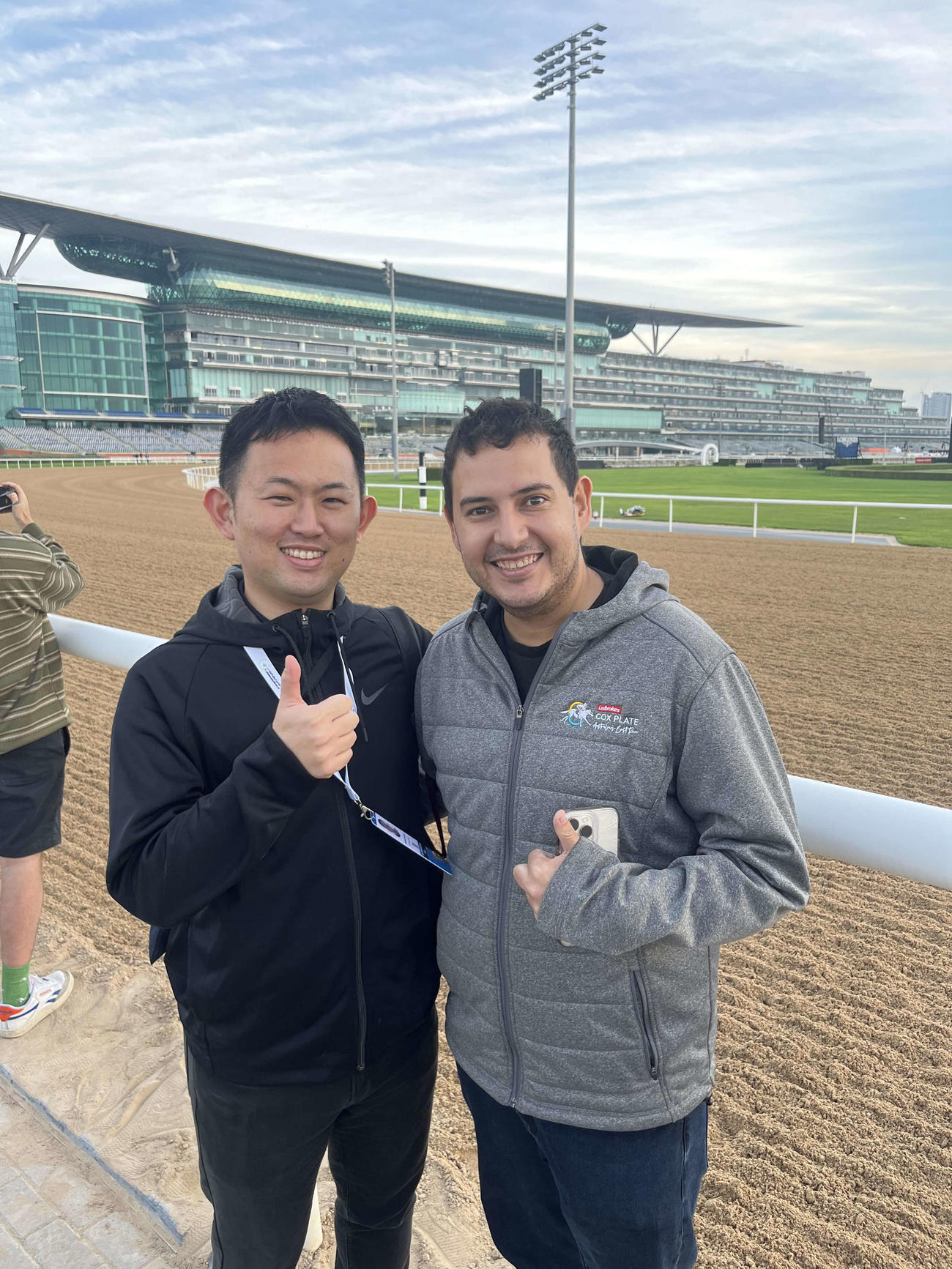 「ワールドホースレーシング」のホーキンス記者（右）とドバイで再会し記念撮影をする桑原記者