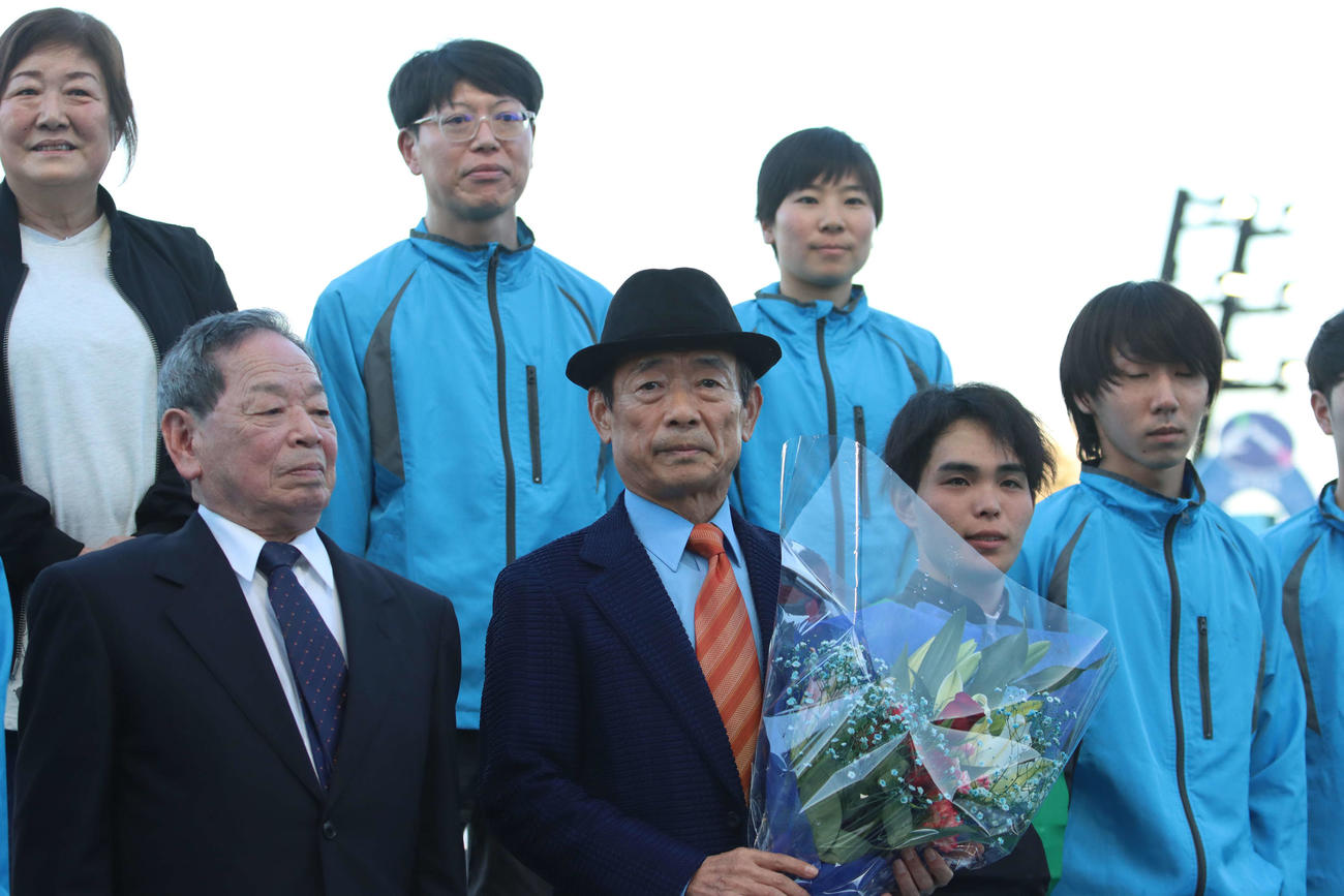 引退セレモニーで花束を受け取り厩舎関係者と記念撮影に納まる浦和の岡田一男調教師（前列左から2人目）
