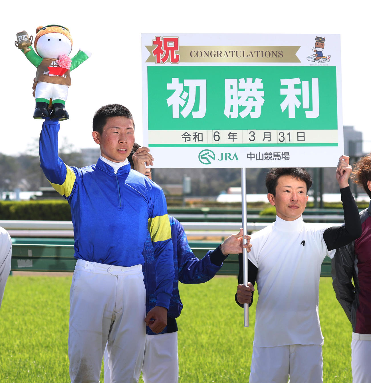 中山1Rで初勝利した石神深道騎手（左）とボードを持つ父石神深一騎手（撮影・柴田隆二）