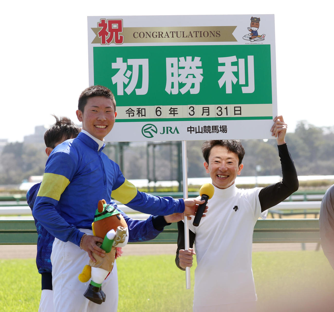 初勝利した石神深道騎手（左）はボードを持つ父石神深一騎手に感想を聞く（撮影・柴田隆二）