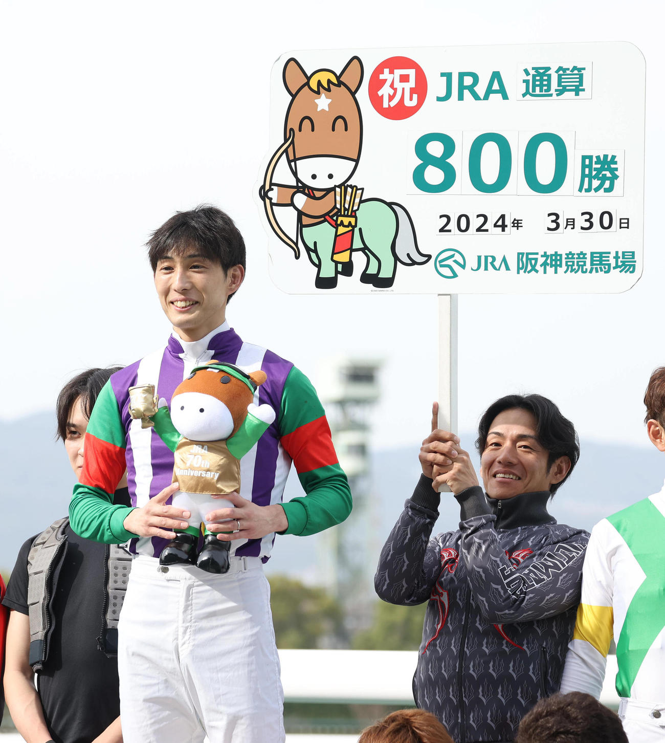 24年、セレモニーで笑顔を見せるJRA通算800勝を挙げた藤岡康太騎手。右はボードを持つ浜中俊騎手