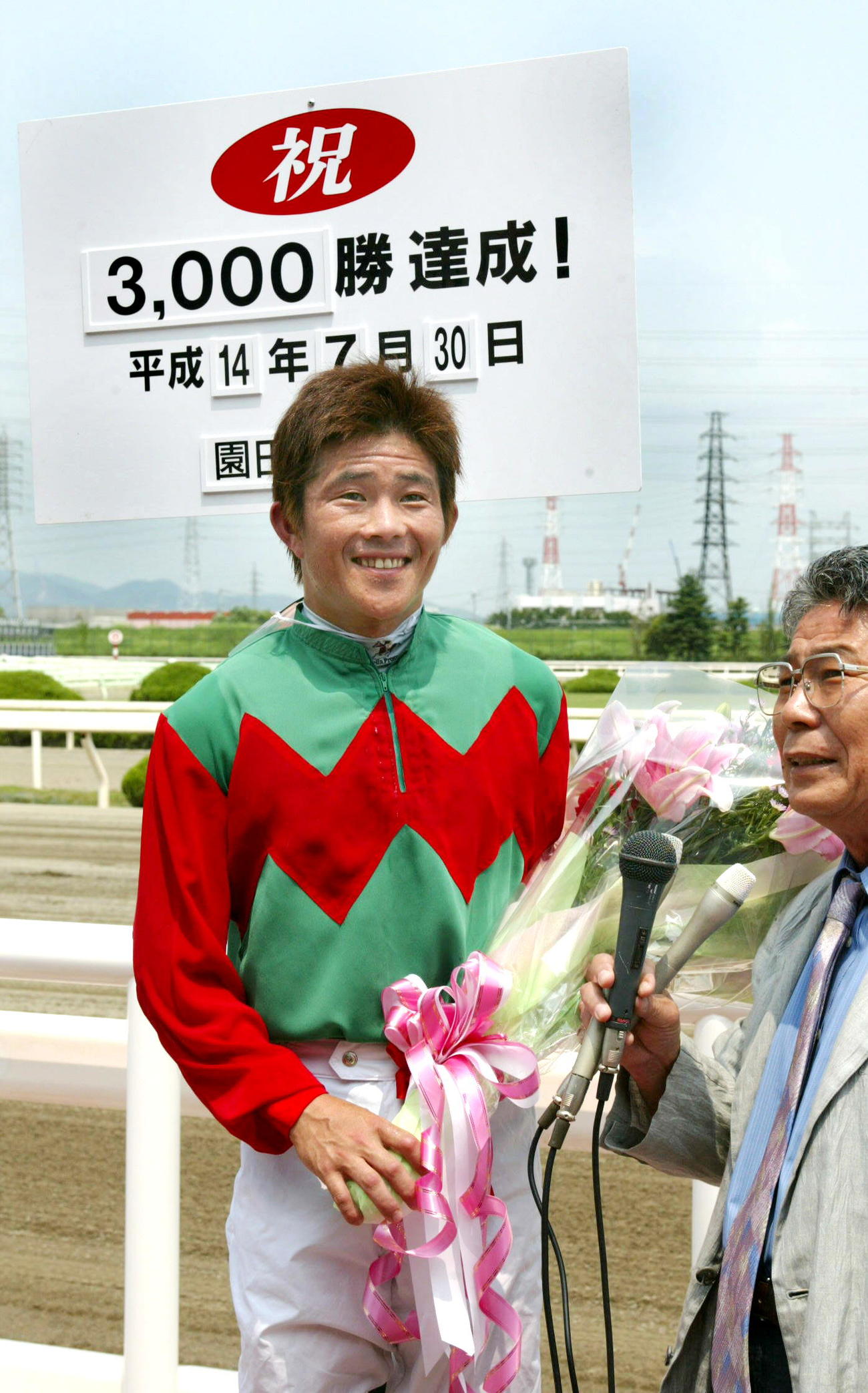 02年、園田競馬で通算3000勝を達成した小牧太騎手は記念のボードの前で笑顔