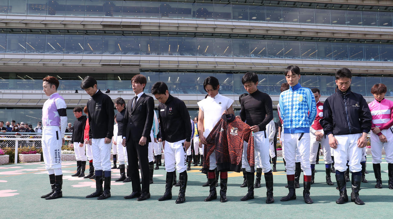 亡くなった藤岡康騎手に黙とうをささげる左から、兄の藤岡佑騎手、武豊騎手、和田竜騎手、川田騎手、浜中騎手、荻野琢騎手、田中健騎手、北村宏騎手ら（撮影・白石智彦）