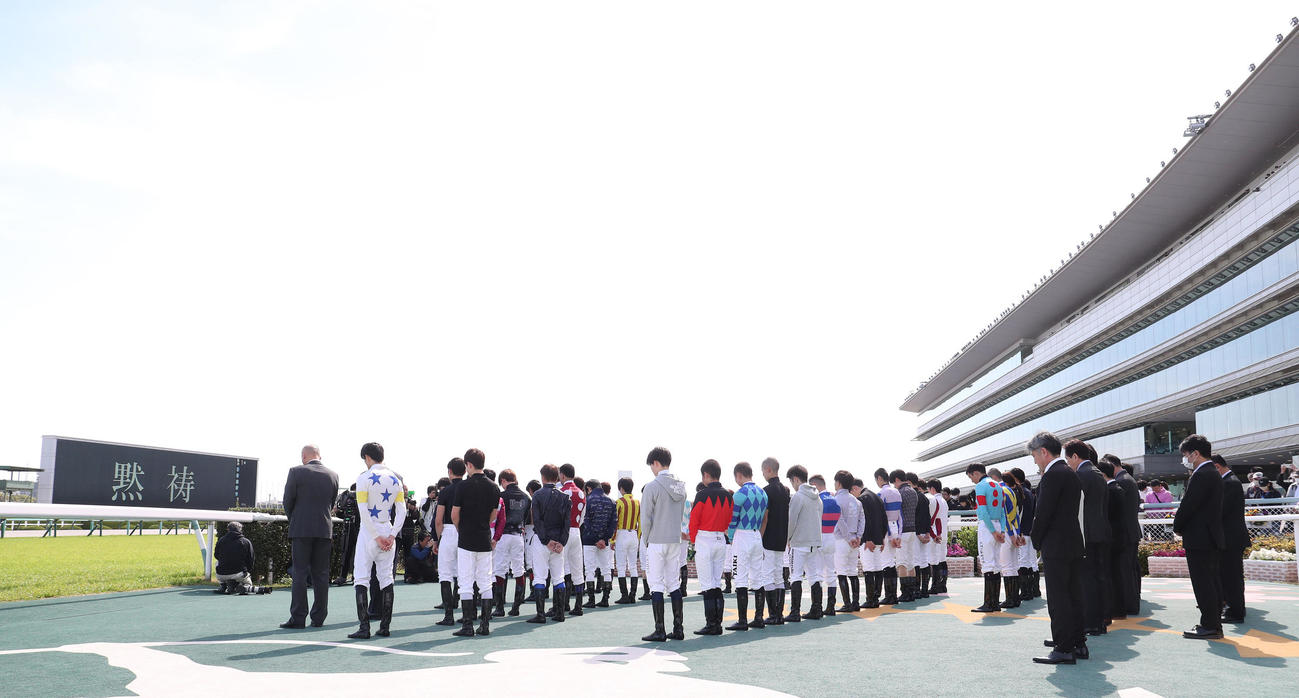 亡くなった藤岡康騎手に黙とうをささげる騎手と関係者（撮影・白石智彦）