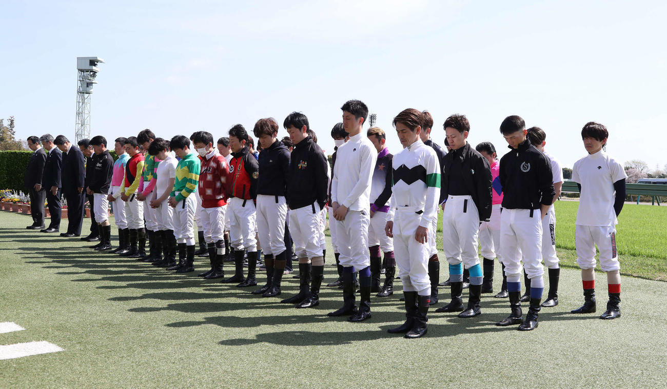 中山競馬場で藤岡康騎手を悼み黙とうする騎手たち（撮影・丹羽敏通）