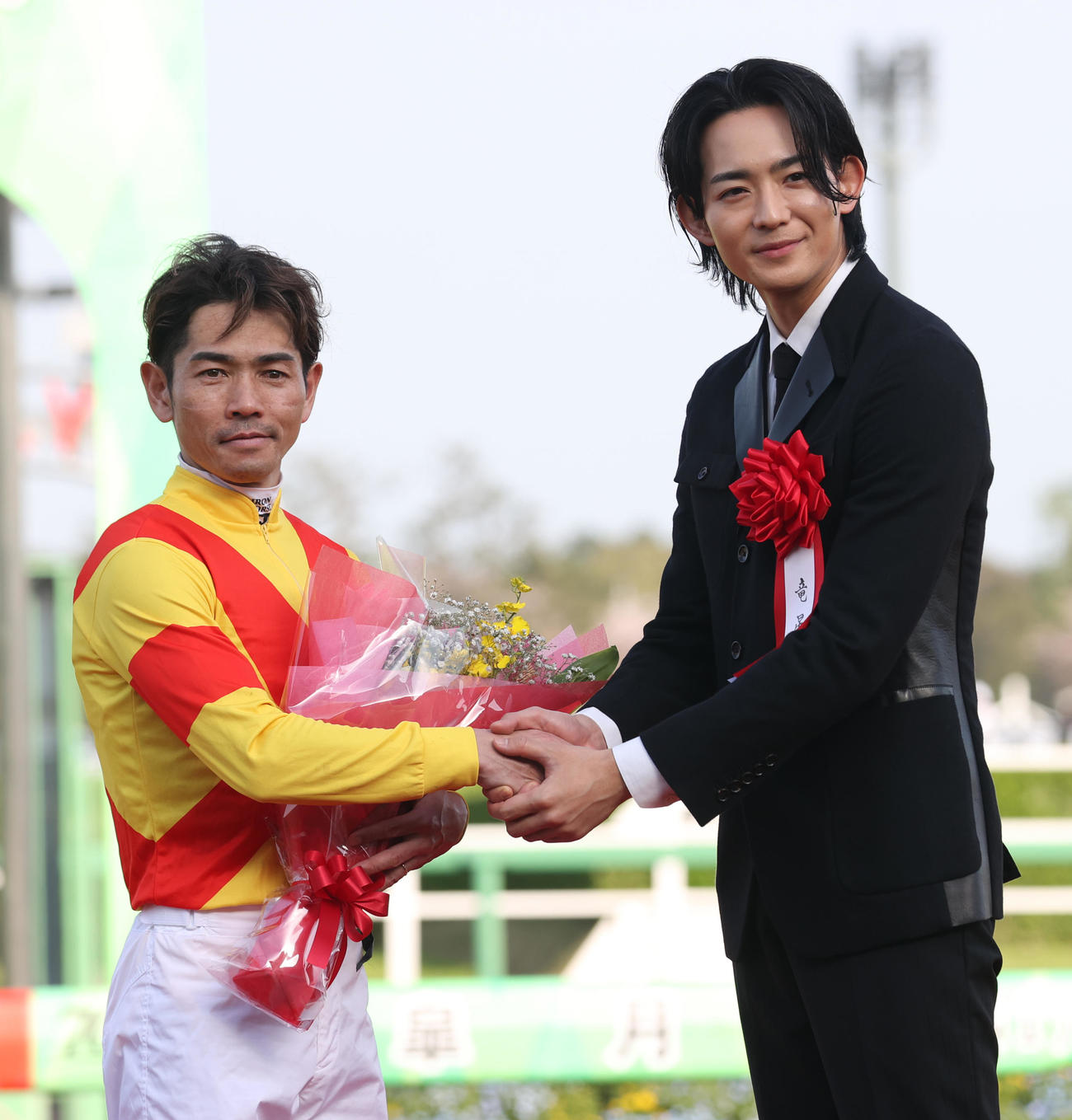 戸崎騎手（左）はプレゼンターの竜星涼と握手する（撮影・柴田隆二）