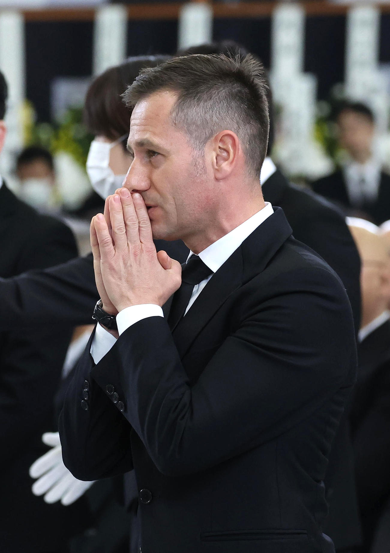 故藤岡康騎手の合同葬で焼香台の前で手を合わせ祭壇を見つめるM・デムーロ騎手（撮影・白石智彦）