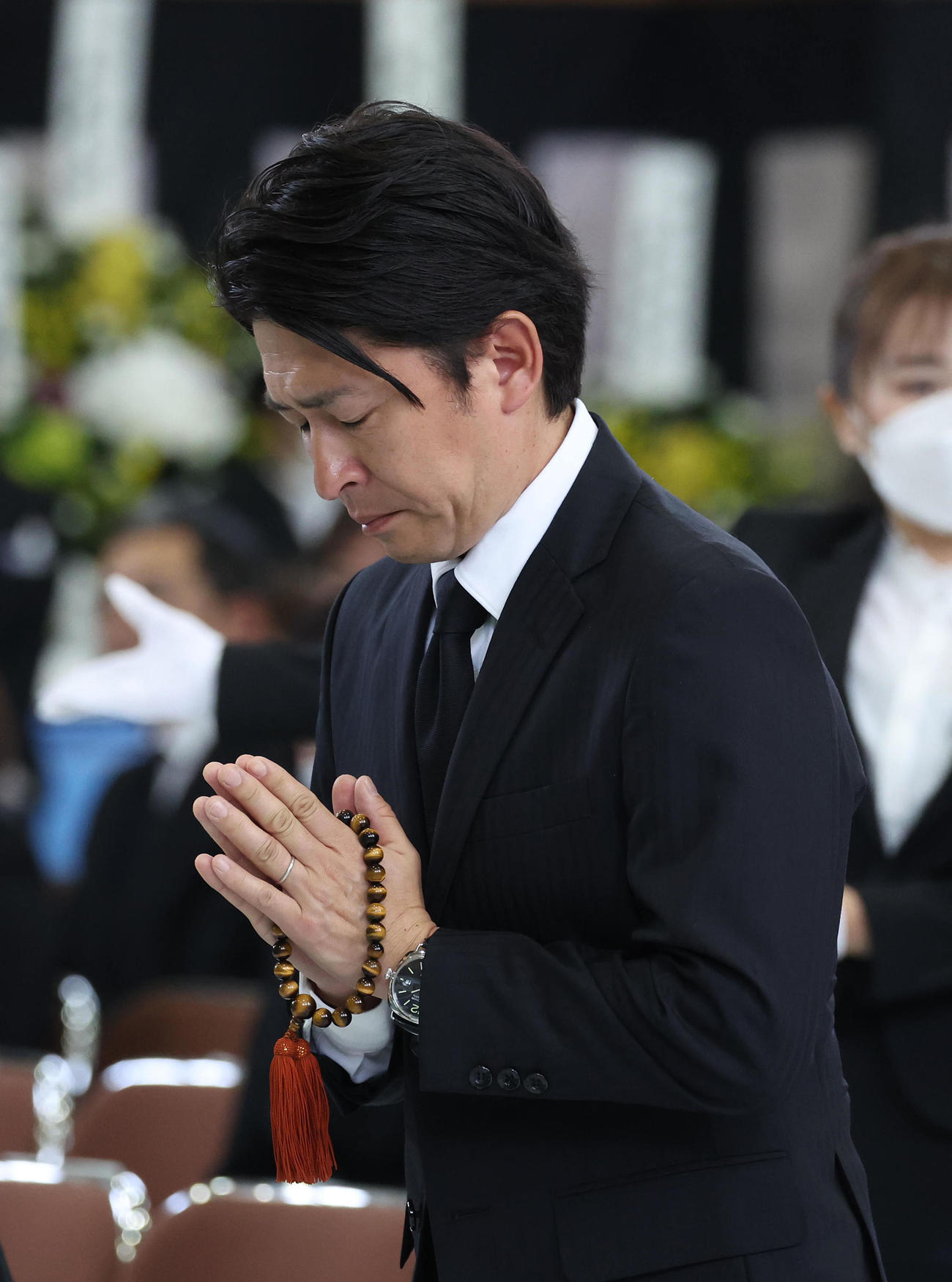 故藤岡康騎手の合同葬で焼香台の前で合掌する福永師（撮影・白石智彦）