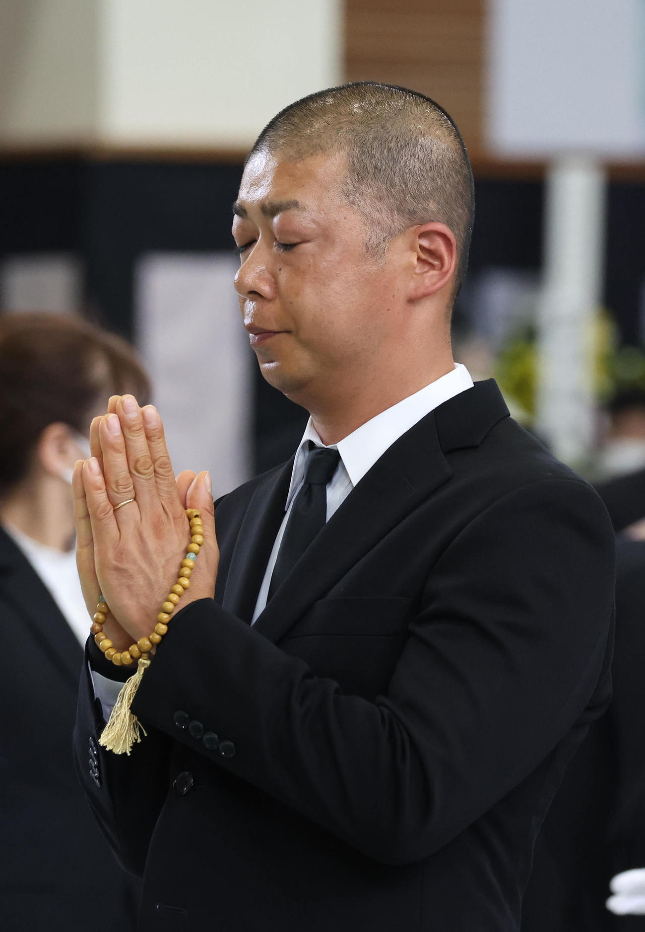 故藤岡康騎手の合同葬で焼香台の前で合掌する高野師（撮影・白石智彦）