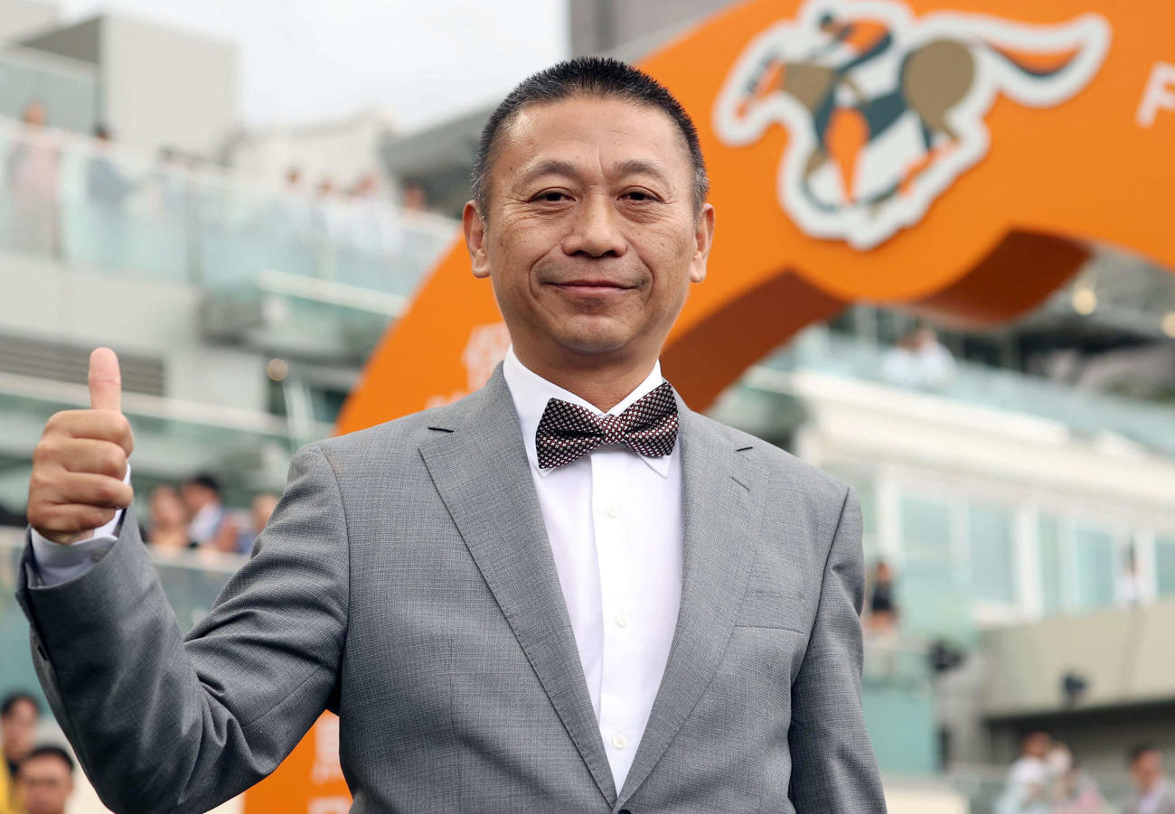 3連覇を達成し、ポーズを取るロマンチックウォリアーのシャム師（（C）The Hong Kong Jockey Club）